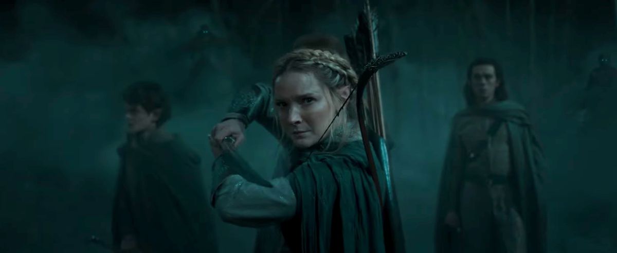 Galadriel (Morfydd Clark) holds a sword with people behind her