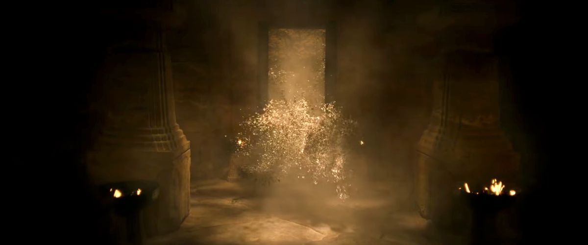 A swarm of what appear to be moth fountains flow through a doorway into a dark room with square stone pillars in the trailer for season 2 of The Lord of the Rings: The Rings of Power