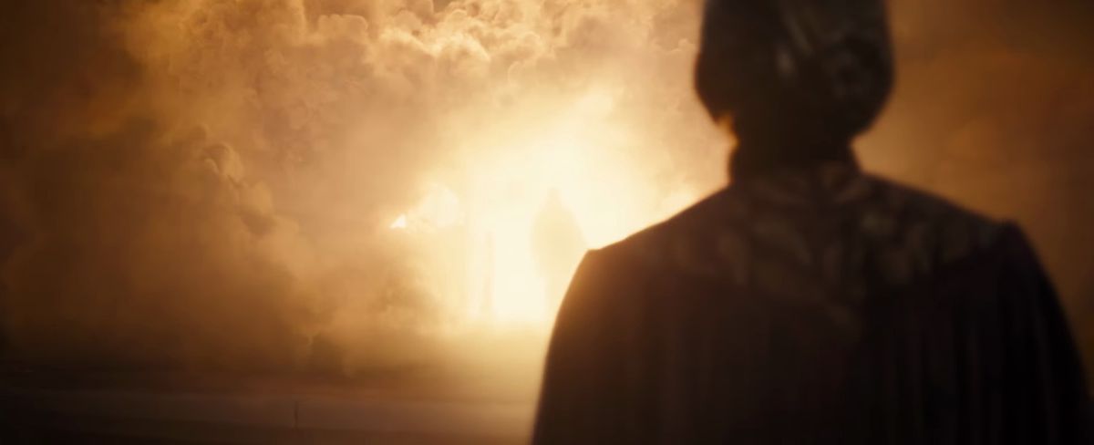 Celebrimbor stands in front of a huge, bright, smoky fire, with a figure in the glowing center in the trailer for Season 2 of The Lord of the Rings: The Rings of Power