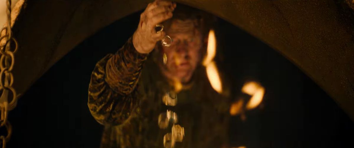 A cascade of gold rings falls from Celebrimbor's hand in The Lord of the Rings: The Rings of Power. 