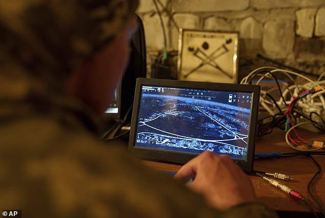 A Ukrainian soldier looks at a screen during the flight of a suicide FPV drone over Russian positions in the Kharkiv region