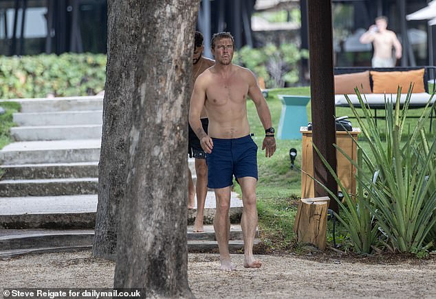 The star, who is staying in an oceanfront hotel that can cost up to £531 a night, walked on the beach before plunging into the Pacific Ocean to wash off the sludge covering his face.