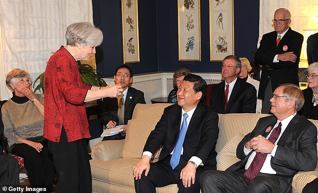 In this award provided by the Iowa Governor's Office, Vice President Xi Jinping of the People's Republic of China sits with Sarah and Roger Lande (R) on February 15, 2012 in Muscatine, Iowa