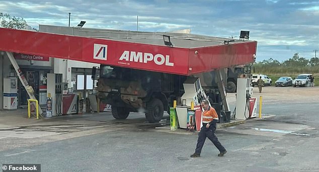 There is extensive damage to the support beams of the crumpled roof and the petrol pumps after being hit by the truck