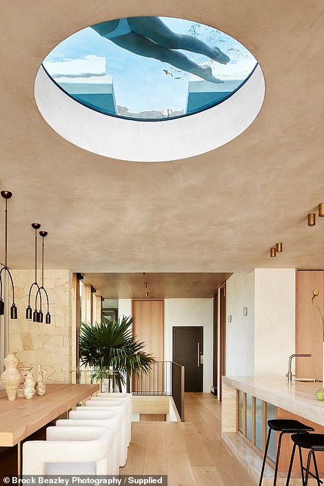 A circular skylight further illuminates the space and provides a playful view through the bottom of the breathtaking rooftop pool