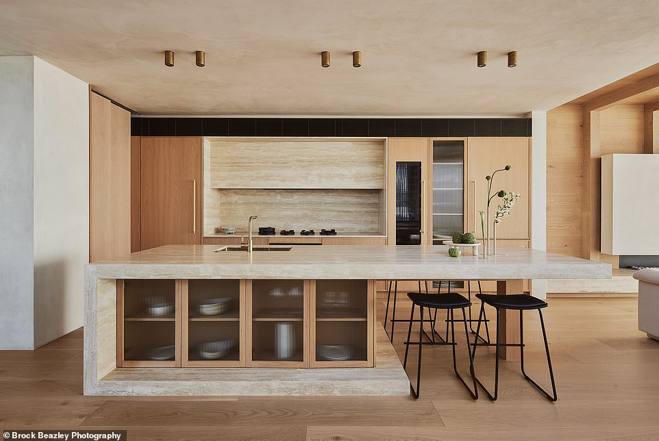 The sleek kitchen is a home cook's dream, with a secret butler's pantry, luxurious gold hardware and a breakfast bar at the end of the stone island bench