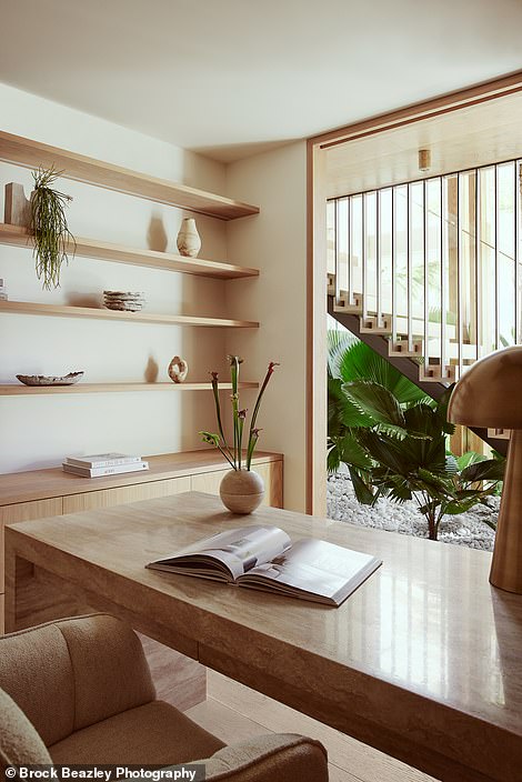 An open staircase connects each floor to a pebble garden with fan ferns at the bottom, creating an internal jungle and breathing life into the house