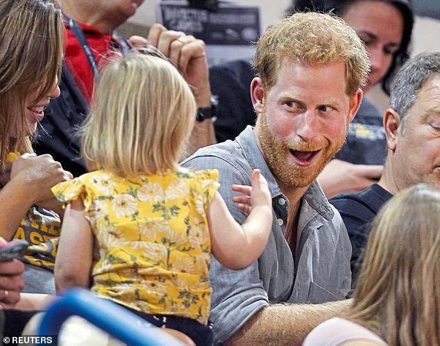 Prince Harry shares popcorn with a child while attending the sitting volleyball competition at the 2017 Invictus Games in Toronto