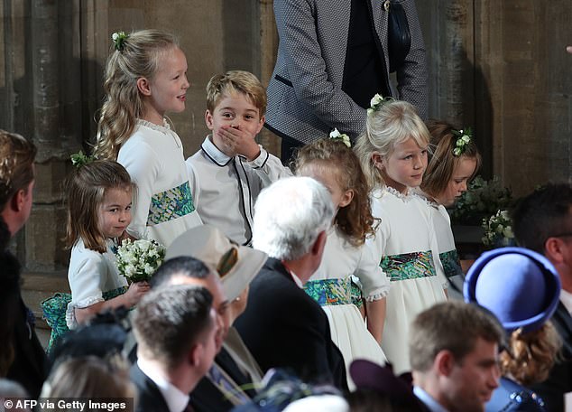 Prince George is caught gossiping with his cousin Savannah Phillips (left) during Princess Eugenie and Jack Brooksbank's wedding in 2018