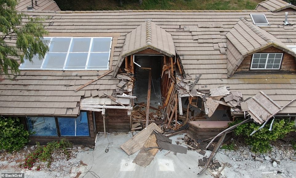 The area around the main house on the property is untouched with dry patches of grass and piles of dirt or sand