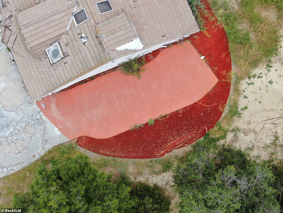 Parts of the concrete driveway have been removed, while one side of the building is partially hidden by red cladding