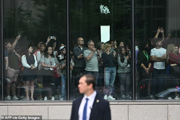 People watch the motorcade with President Joe Biden near the National Museum of African American History and Culture