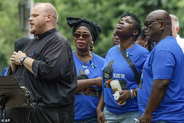 Harris' family prays with Rev. Jonathan Slavinskas during a vigil in Worcester, Massachusetts, on September 8, 2023