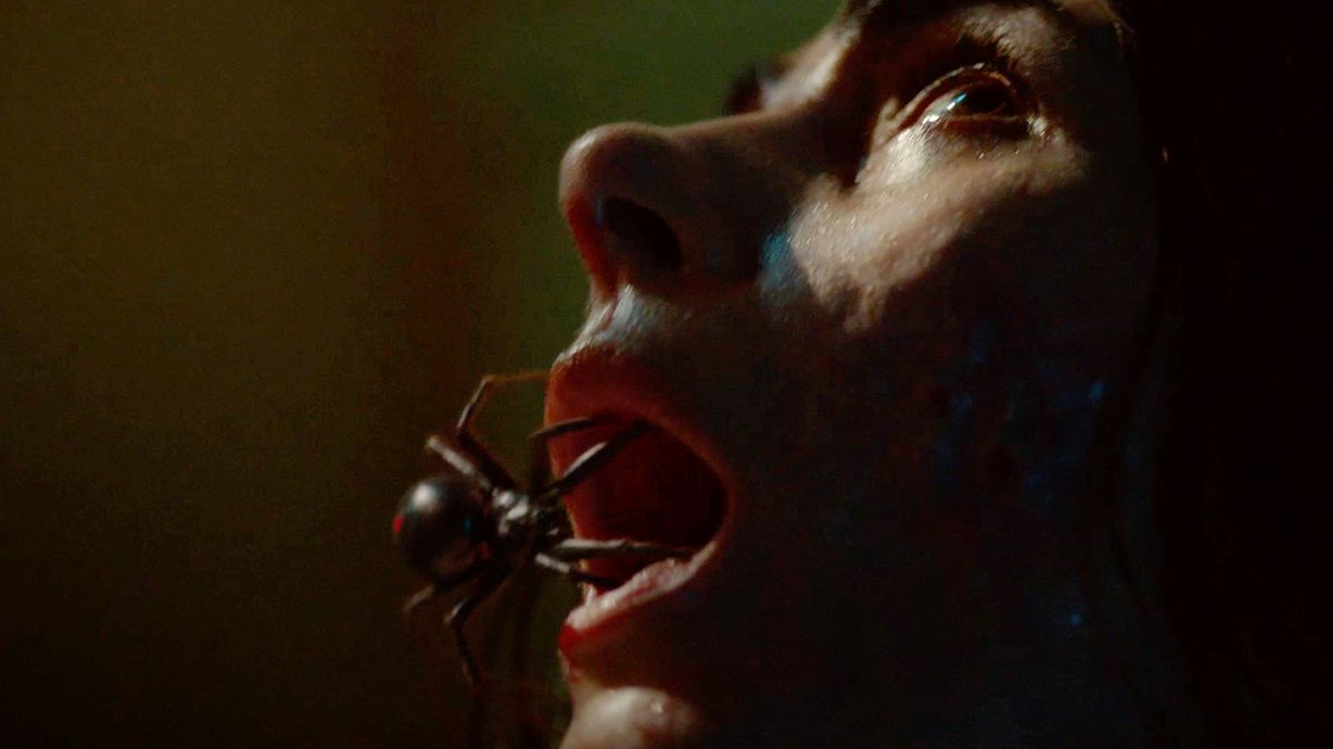A spider crawls into the open mouth of a terrified woman.