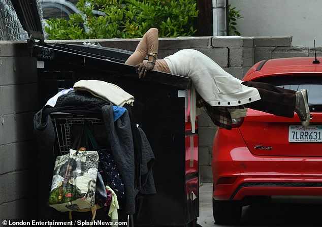 In one of the photos, Loni was seen throwing herself into a dumpster with the girth of her bra poking through her thin top