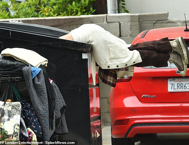 She tied a flannel shirt and white jacket around her waist before throwing a red baseball cap over her cropped locks