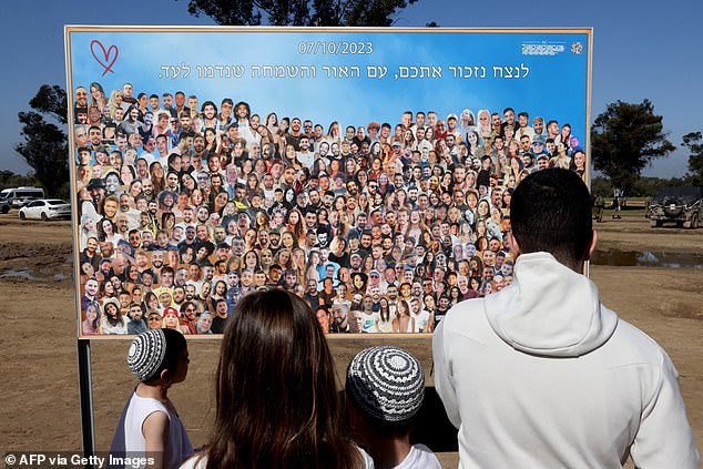 In total, about 1,200 people died and 6,900 were injured.  The vast majority were civilians, and many were infants and young children.  People stare at a poster with images of young people captured or killed by Hamas militants