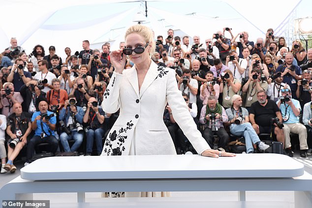 Uma stylishly pulled down her sunglasses as she stood behind a huge stage