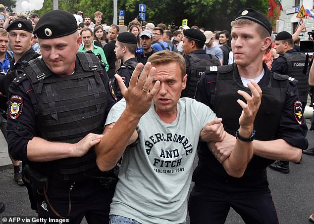 Opposition leader Alexei Navalny is detained by Russian police officers during a march to protest the alleged impunity of law enforcement agencies in central Moscow on June 12, 2019