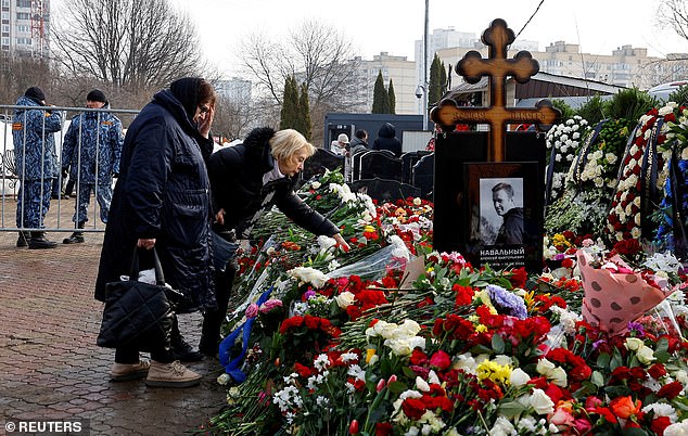 The mothers of Russian opposition leader Alexei Navalny and his widow Yulia Navalnaya, Lyudmila and Alla, stand in front of Navalny's grave on March 2, 2024, the day after his burial at Borisovskoye Cemetery in Moscow