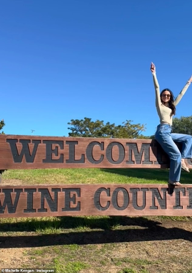 In another photo, Netflix star Michelle looked stunning as she threw her arms in the air as she posed on a giant wooden sign that read 'Welcome to Wine Country'.