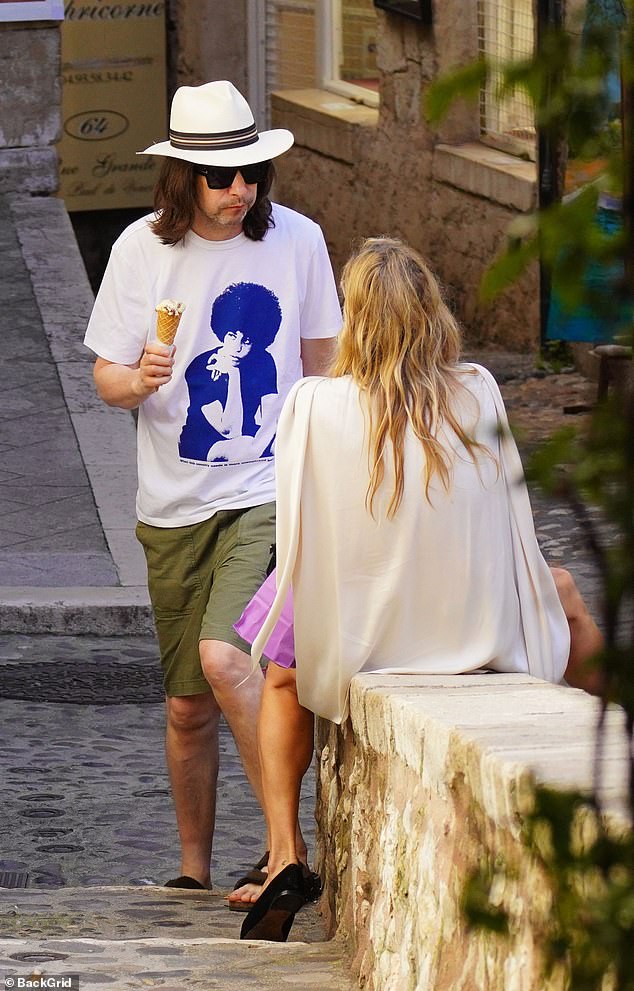 Meanwhile, Primal Scream rocker Bobby, 52, wore a white T-shirt and khaki shorts as he caught up with his friend