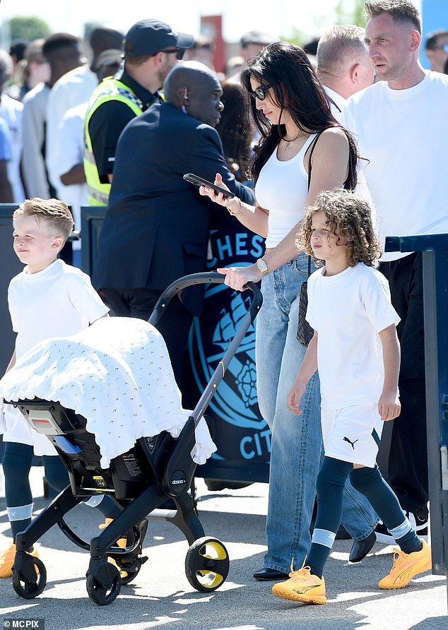 Footballer's youthful Annie, 31, dressed for the weather in a white vest and sunglasses as she arrived at the Etihad Stadium on Sunday