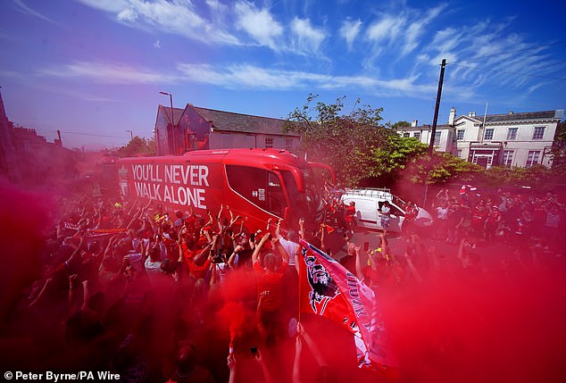 Supporters light red smoke flares as they welcome Jurgen Klopp for his final game in charge