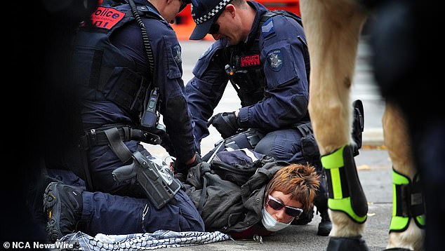 Six people were arrested, including three for obstructing police (in the photo, police restrain a protester)