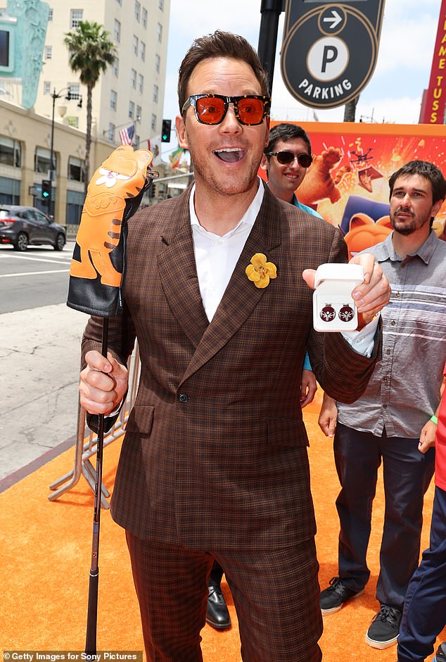 The actor had fun posing with a few props, including a Garfield golf club cover, sunglasses and earrings shaped like Christmas tree ornaments