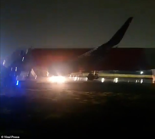 Later, the video, now taken from outside the plane on the runway, shows emergency services rushing towards the plane with loud shouting in the background as the commotion continues.  Miraculously, no one was injured in the incident, which saw a 'full emergency' declared by air traffic control staff and forced the plane to make a dramatic landing.