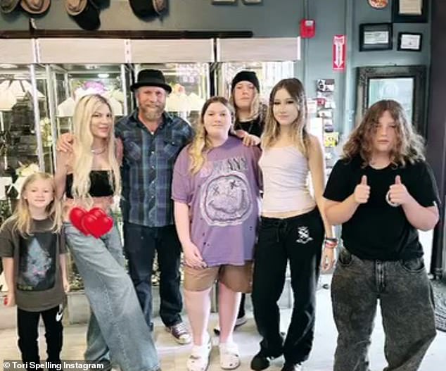 In the salon photos, Spelling wore a black bandeau top, which exposed her abs, and wide-leg jeans with a low rise.  Her five children all wore casual clothes as they joined her for Mother's Day