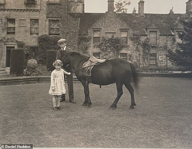 Young Elizabeth plays with a pony in the grounds of Glamis Castle wearing the floral dress now up for auction