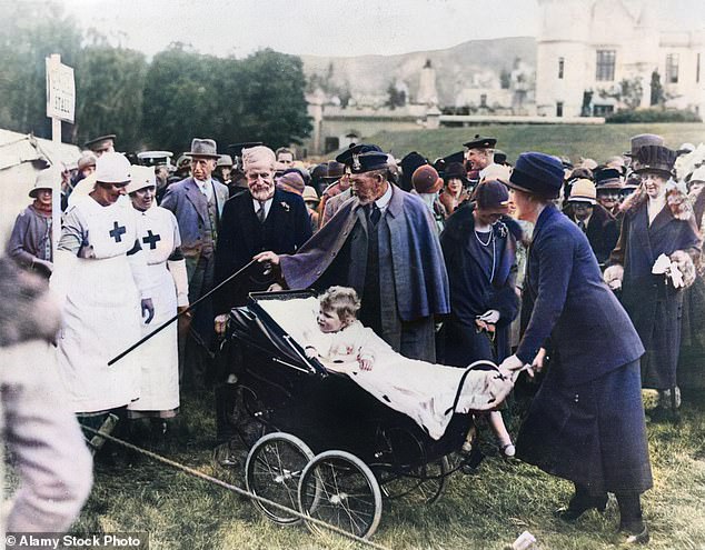 The future Queen Elizabeth II is pushed in a stroller by her nanny Clara Knight and accompanied by her grandfather, King George V