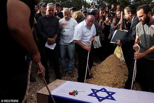 Mourners lowered Shani's coffin into the grave during her funeral in Srigim last night