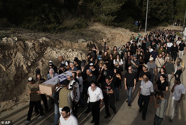 Mourners carry Shani Louk's flag-covered coffin during her funeral in Srigim, Israel