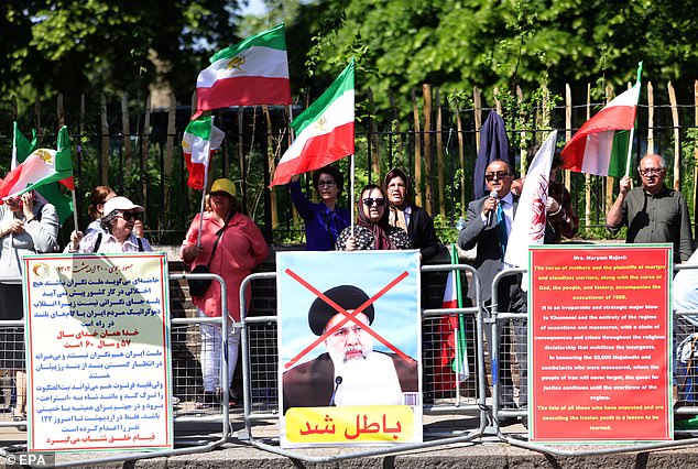 Protesters from the anti-government group National Council of Resistance of Iran were seen waving old Iranian flags outside Iran's embassy in London