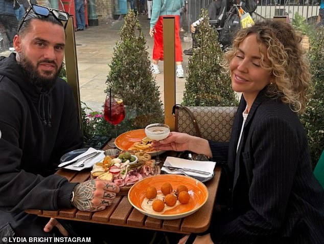 In the adorable post, the couple posed while sharing a charcuterie board and cocktail in Covent Gardens in London
