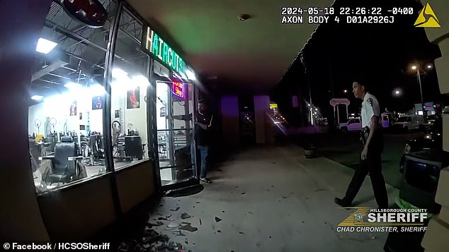 Another group of rioters beat a youth before throwing him through a glass window of a nearby barbershop.  Pictured is the broken glass after the attack on the Time Out Barber Shop