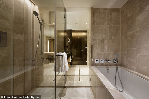 The marble-clad bathroom in a Premier room has a walk-in shower and deep soaking bath