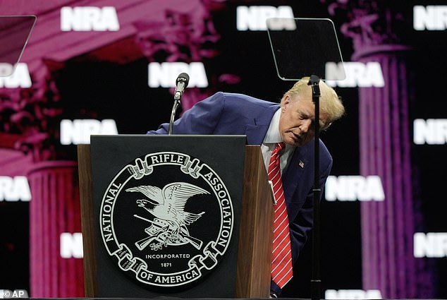 Trump looks around after making a joke during his speech at the National Rifle Association Convention