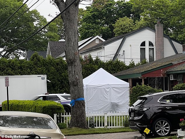 White tents are set up outside the Massapequa Park home on First Avenue as NYS Troopers block the street