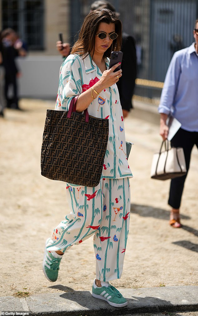 Pictured: A glamorous guest wearing green Adidas Gazelles with a printed co-ord set during Paris Fashion Week in June 2023