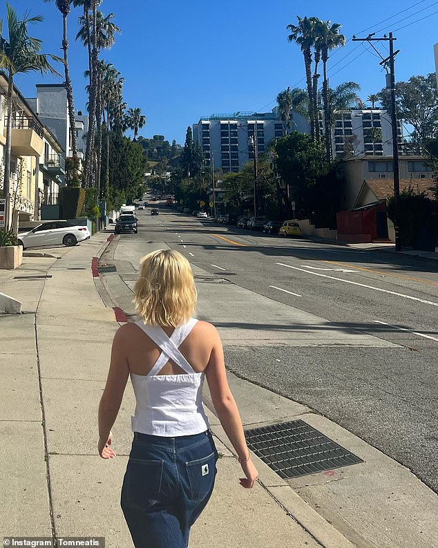 In another photo, the blonde bombshell wears blue jeans and a white strappy top as she walks away from the camera