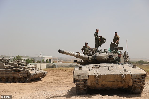 Israeli soldiers with their tanks gather at a secret location near the border fence with the Gaza Strip, in southern Israel, May 21, 2024