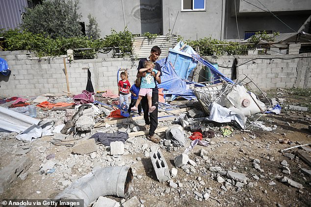 Civil defense teams and civilians carry out search and rescue operations under the destroyed building after the Israeli attack on the Az-Zawayda neighborhood, in Deir al-Balah, Gaza on May 22, 2024