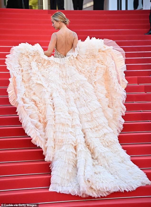 She stepped out in a sheer nude dress with intricate jewel details, which she paired with a dramatic cream-colored layered tulle scarf that doubled as a train.