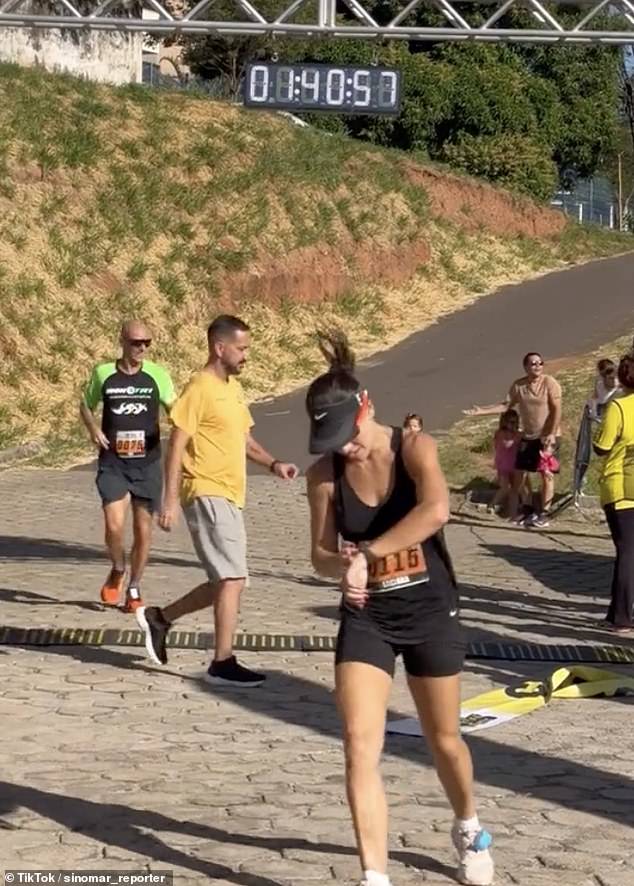 The woman avoids the young girls to get to the finish line faster, prompting a confused reaction from the man believed to be their father