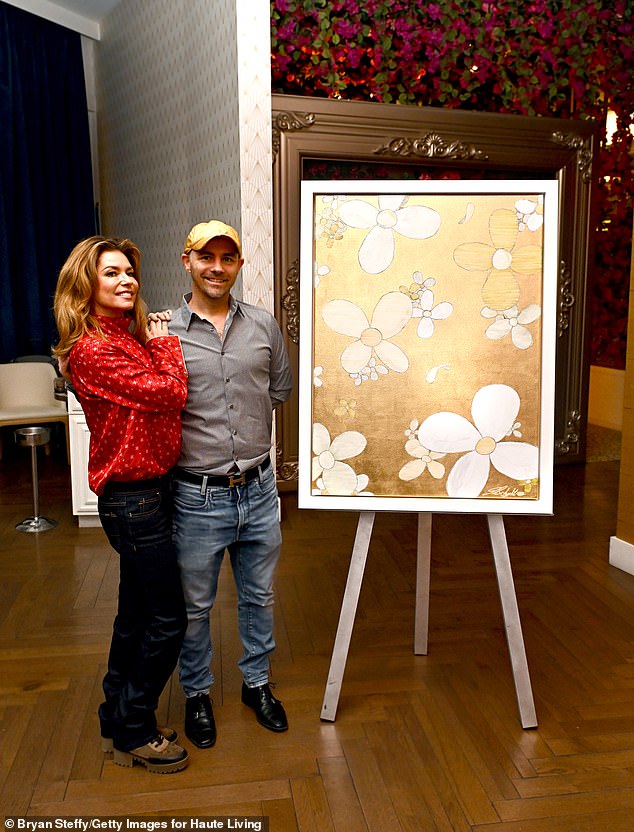 The event honored five-time Grammy winner and artist Jonathan Schultz (R), who presented her with a custom gold floral artwork
