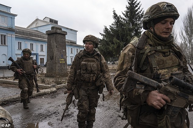 Ukrainian soldiers recently returned from Bakhmut's trenches walk down a street in Khasiv Yar, Ukraine